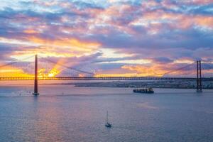 visie van 25 de abril brug over- tagus rivier- Aan zonsondergang. Lissabon, Portugal foto