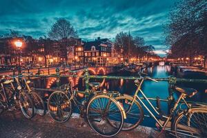 Amsterdam kanaal, brug en middeleeuws huizen in de avond foto