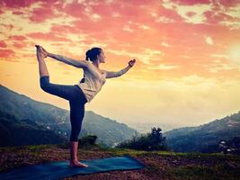 vrouw aan het doen yoga asana natarajasana buitenshuis Bij waterval foto