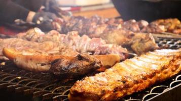 gebakken varkensribbetjes. gegrilde varkensvlees kebab op een theepot. barbecue kind op de grill. gegrilde kebab, kebab. festival van heerlijk gefrituurd straatvoedsel. het vlees op het bot, het kookproces foto