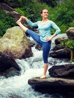 vrouw aan het doen Ashtanga Vinyasa yoga asana buitenshuis Bij waterval foto