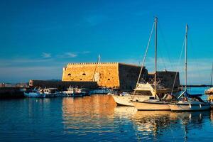 Venetiaanse fort in Iraklion en afgemeerd visvangst boten, Kreta eiland, Griekenland foto