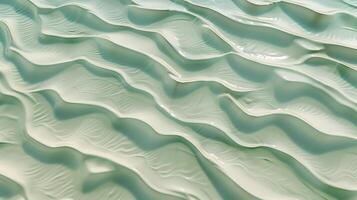 een structuur van rimpelingen Aan zand, met klein golven Aan de oppervlak, licht groen tint. foto