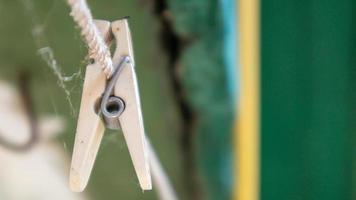 plastic wasknijpers hangen in een rij aan het touw. touw buitenshuis, op een onscherpe achtergrond in een zonnige tuin. waslijn op straat. wasknijpers. foto