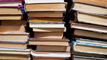 veel gebruikte oude boeken in de schoolbibliotheek. chaotische lay-out van stapels literatuur, selectieve focus. een stapel boeken eindigt met gestapelde achtergrond. boeken in een bibliotheek - backdrop foto