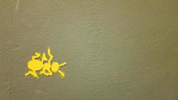 geel geschilderde mier op een grijze muur. mier die een muur beklimt. kleurrijke mieren achtergronden. lokale kunstenaars versieren de muren van de straten. foto