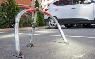 handmatige grijze gegalvaniseerde metalen parkeerbarrière met slot. parkeerslot apparaat. parkeerbarrière geplaatst. een opvouwbare barrière voorkomt dat het voertuig op dit punt stopt. gereserveerde stoel. foto