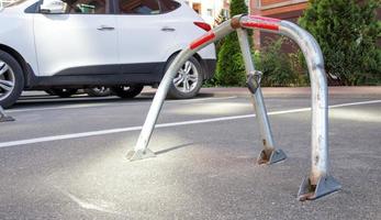 handmatige parkeerbarrière van grijs verzinkt metaal met slot. parkeerbarrière geplaatst. een inklapbare barrière voorkomt dat het voertuig op dit punt stopt. foto