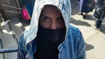 portret van een vrouw met een beschermend zwart masker buitenshuis. coronavirus en luchtvervuilingsconcept. het meisje draagt een beschermend masker ter bescherming tegen een pandemie foto