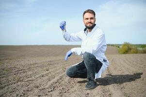 agronoom aan het studeren monsters van bodem in veld- foto