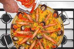 stap voor stap gids naar maken paella Valenciana, een klassiek Spaans schotel met zeevruchten en saffraan rijst- foto