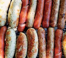 mengen van knakworsten en worstjes gegrild Aan barbecue foto