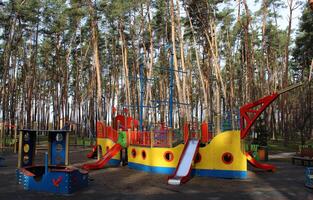 zandbak, veelkleurig dia's en schommels Aan de speelplaats voor actief spellen in de groen Oppervlakte foto