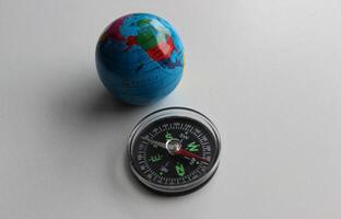 klein wereldbol en ronde kompas geïsoleerd Aan wit voorraad foto