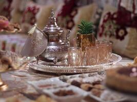 traditioneel Marokkaans thee reeks weergegeven elegant Aan een zilver dienblad foto
