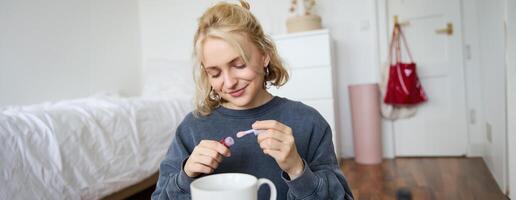 portret van jong blond meisje, zet Aan lip glans terwijl krijgen klaar voor feest. levensstijl blogger, vrouw inhoud Schepper opname van haar met bedenken foto