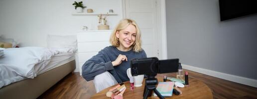 portret van jong mooi vrouw, levensstijl blogger, pratend over bedenken Aan camera, opname vloggen, beoordelingen Product voor sociaal media account, vlogger werken in haar kamer foto