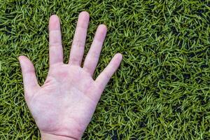 meisje hand- Aan voetbal veld- gras foto