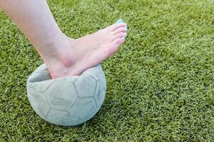 meisje blootsvoets en oud voetbal bal foto