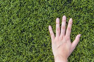 meisje hand- Aan voetbal veld- gras foto