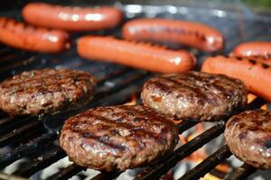 barbecue rooster sissend met sappig hamburgers en hotdogs, nietje van zomer bijeenkomsten foto