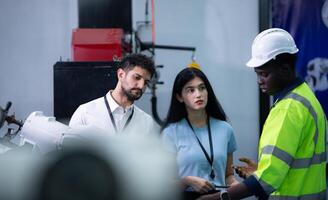 technici zijn introduceren industrieel hand- robots naar zakenman van fabriek industrie wie zullen gebruik hen in grootschalige complex fabricage activiteiten. foto