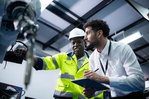 technici zijn introduceren industrieel hand- robots naar zakenman van fabriek industrie wie zullen gebruik hen in grootschalige complex fabricage activiteiten. foto