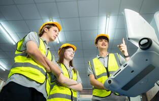 beide van jong fabriek arbeider vervelend een moeilijk hoed op zoek Bij een computer scherm gebruikt naar controle productie. foto