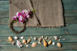 verscheidenheid van zee schelpen en orhid bloemen Aan een houten achtergrond foto