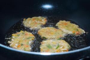 de werkwijze van menging rauw groenten en tarwe meel is gebakken Aan een frituren pan foto