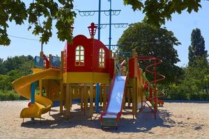 zomer voorjaar kinderen speelplaats met geschilderd speelgoed- glijbaan in park foto