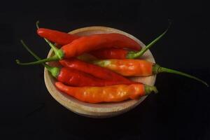 sommige heet rood pepers zijn zittend Aan een houten bord foto