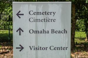 directioneel teken Bij Amerikaans begraafplaats Bij Normandië Oppervlakte. foto