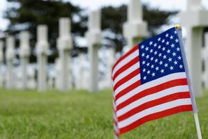 Amerikaans vlag in voorkant van Amerikaans begraafplaats graven Bij Normandië Oppervlakte. Tweede Wereldoorlog gedenkteken. foto