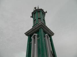 foto van de moskee toren genomen van de top verdieping van een meerdere verdiepingen gebouw. de moskee toren is gebruikt net zo een markeerstift en ook net zo een luidspreker