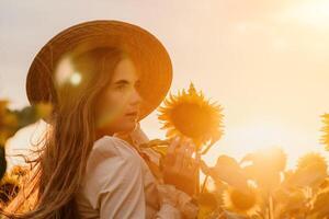 vrouw in zonnebloem veld. gelukkig meisje in een rietje hoed poseren in een enorm veld- van zonnebloemen Bij zonsondergang, genieten nemen afbeelding buitenshuis voor herinneringen. zomer tijd. foto