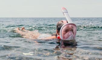 jong gelukkig vrouw in wit bikini en vervelend roze masker krijgt klaar voor zee snorkelen. positief glimlachen vrouw ontspannende en genieten van water activiteiten met familie zomer reizen vakantie vakantie Aan zee. foto