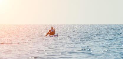 Mens zee kajak. gelukkig vrij Mens in kajak Aan oceaan, peddelen met houten roeispaan. kalmte zee water en horizon in achtergrond. actief levensstijl Bij zee. zomer vakantie. foto