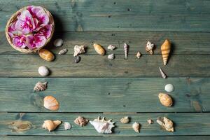 verscheidenheid van zee schelpen en orhid bloemen Aan een houten achtergrond foto