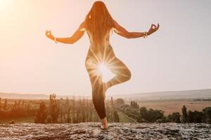 geschiktheid vrouw. gelukkig middelbare leeftijd geschiktheid vrouw aan het doen uitrekken en pilates Aan een rots in de buurt Woud Bij zonsondergang. vrouw geschiktheid yoga routine. gezond levensstijl met focus Aan welzijn en ontspanning. foto