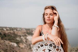 gelukkig boho vrouw portret. boho chique mode stijl. buitenshuis foto van vrij gelukkig vrouw met lang haar, zonnig weer buitenshuis met zee bergen natuur mooi achtergrond.