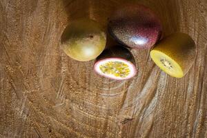 sappig van passie fruit en kiwi Aan een houten achtergrond foto