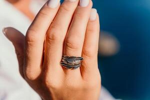 vrouw hand- met een ring met veren Aan haar vinger foto