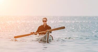 vrouw zee kajak. gelukkig glimlachen vrouw in kajak Aan oceaan, peddelen met houten roeispaan. kalmte zee water en horizon in achtergrond. actief levensstijl Bij zee. zomer vakantie. foto