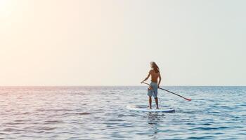 Mens sup zee. sterk atletisch Mens leert naar peddelen sup staand Aan bord in Open zee oceaan Aan zonnig dag. zomer vakantie vakantie en reizen concept. antenne visie. langzaam beweging foto