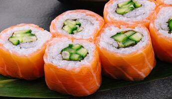 Philadelphia Zalm sushi met komkommer binnen Aan bord foto