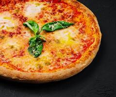 margherita pizza met basilicum Aan zwart steen foto