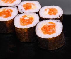 Zalm maki sushi Aan zwart steen bord foto