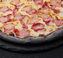 zwart deeg pizza met kaas en ham foto