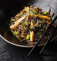 pittig gerecht, noedels met vlees en groenten in wok pan foto